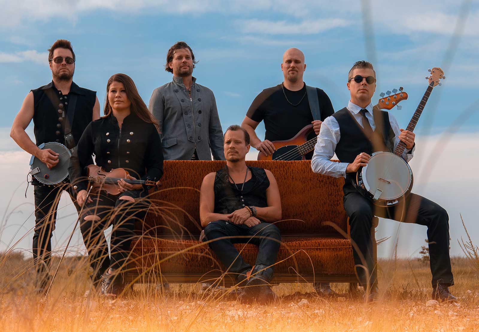 The six Haygoods posed outdoors with a violin, banjo, and bass guitars