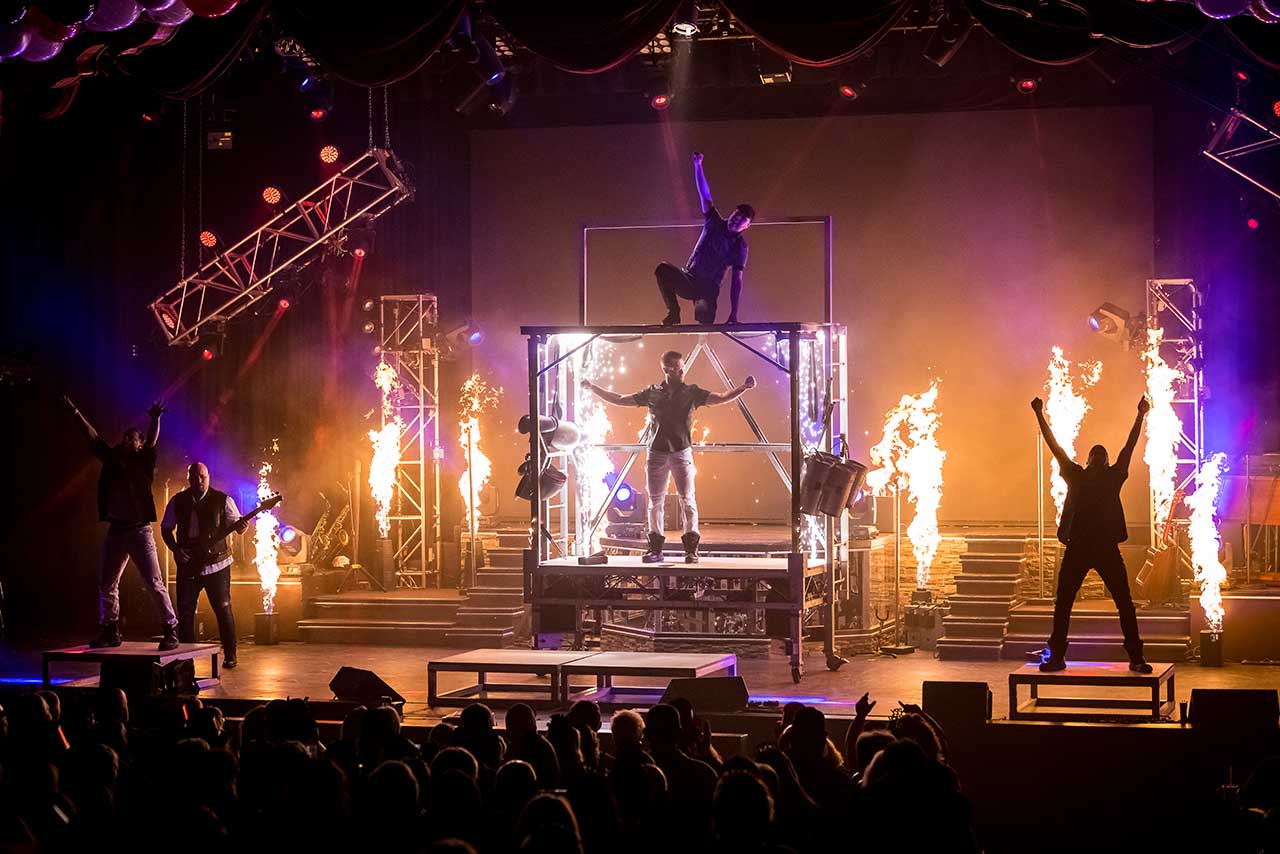 The Haygoods performing amid fire effects and an elevated stage structure