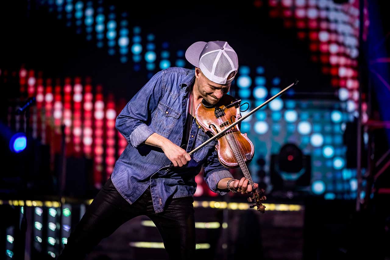 A Haygoods performer playing violin and guitar on stage