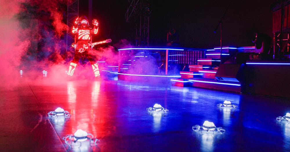 Illuminated drones surrounding a guitar performer on the Haygoods stage