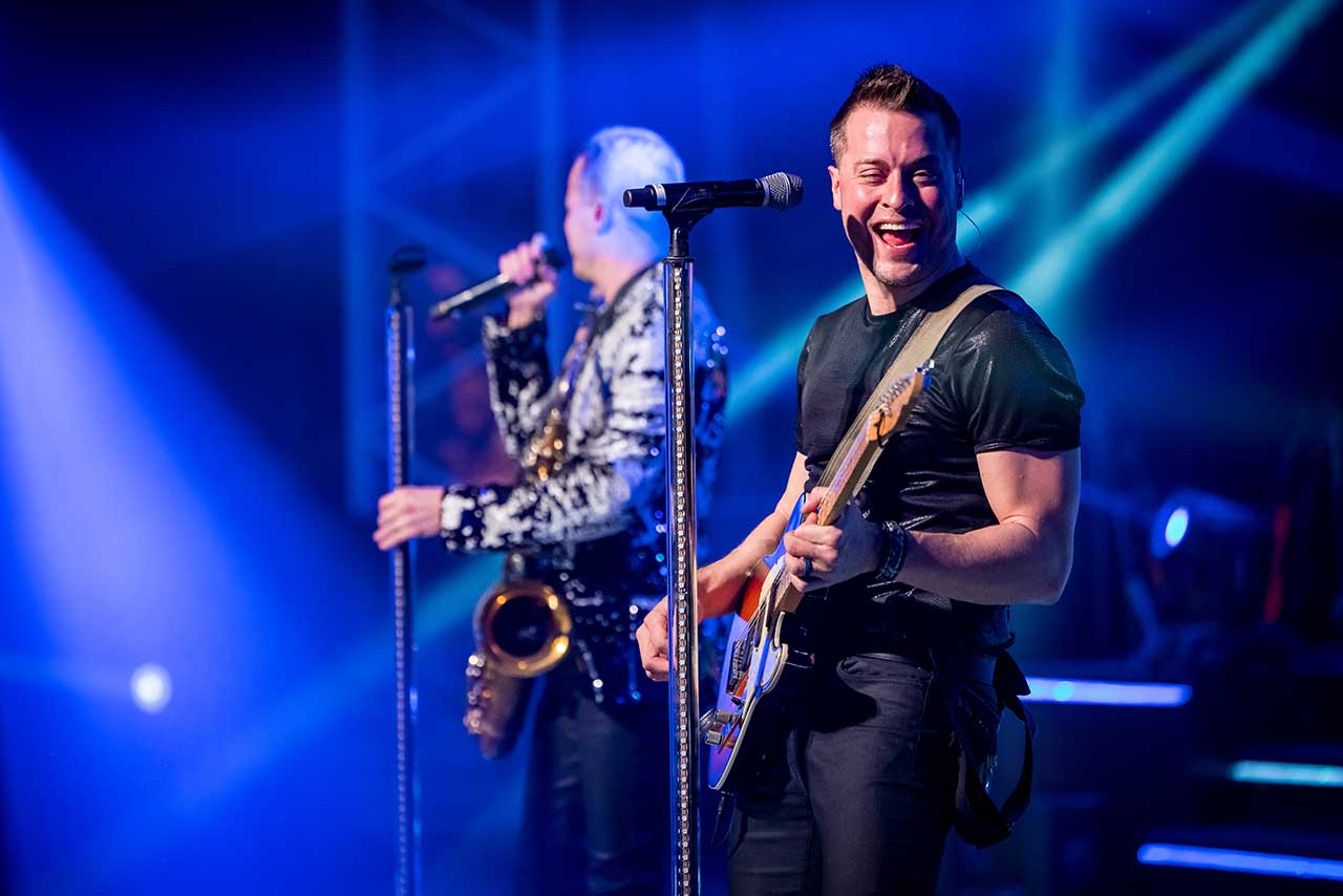 Michael Haygood smiling while playing guitar onstage