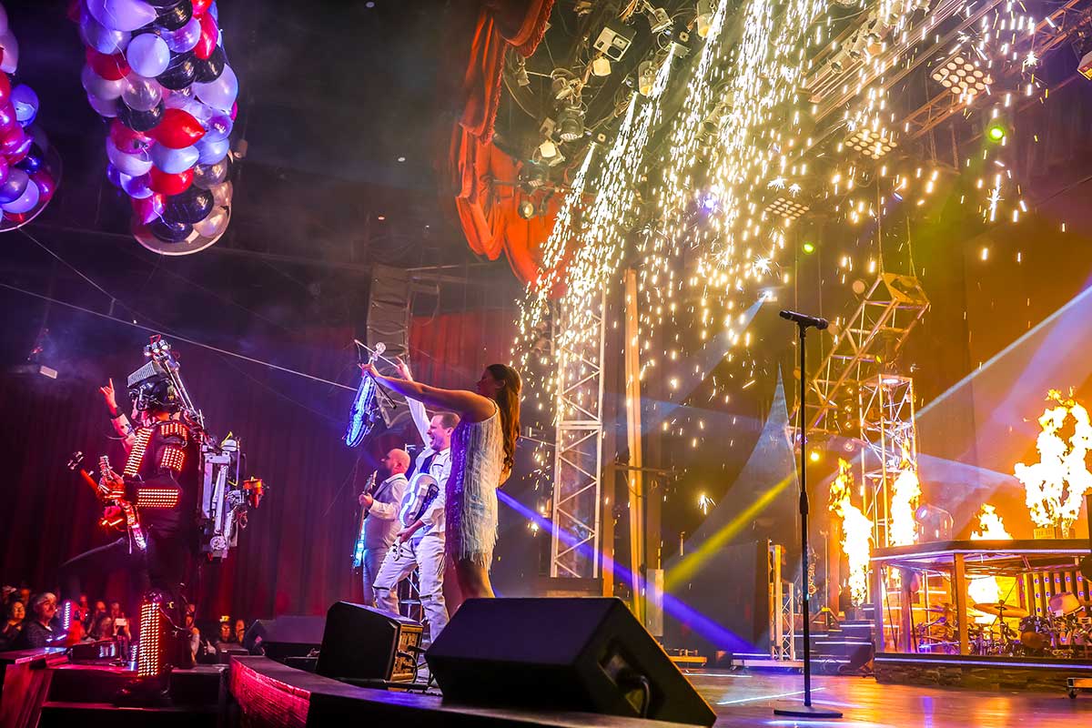 The Haygoods performing beside sparks, fire, and illuminated stage effects